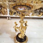 میوه خوری برنزی کنار سالنی ایستاده سه پسر بچه پایه سنگ مشکی